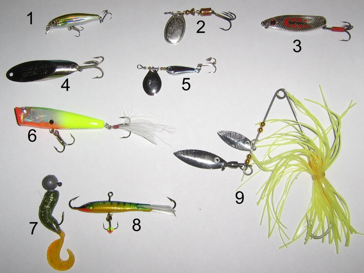 Assortment of spoons, spinners, crankbaits and a spinnerbait laid out for packing