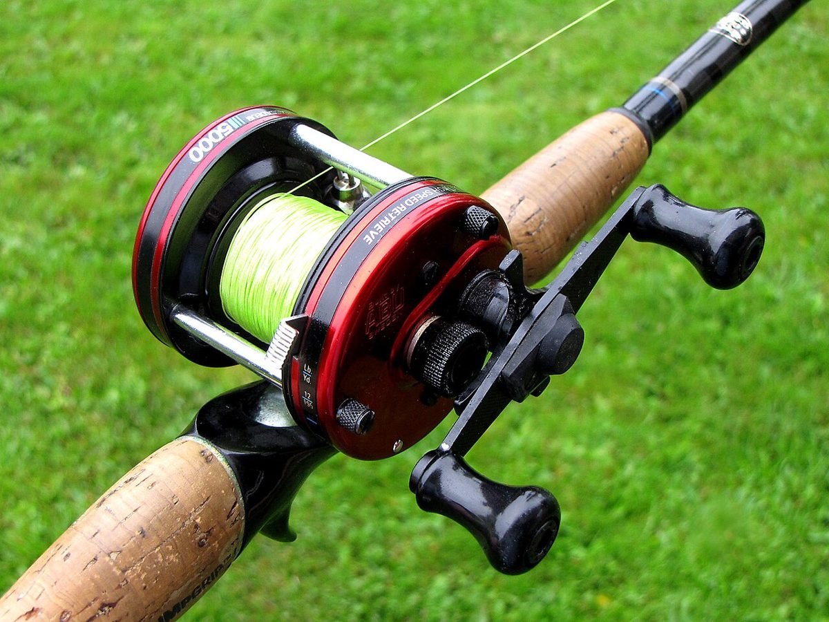Round baitcasting reel spooled with line, mounted on a cork-handled casting rod