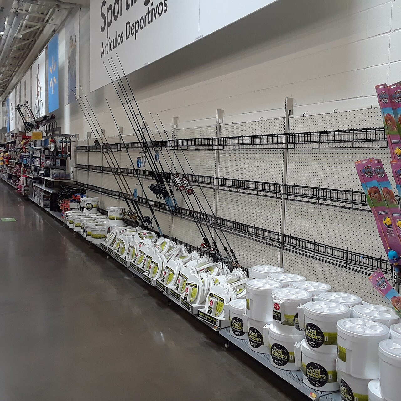 Fishing rods stored on horizontal wall racks in a sporting goods store