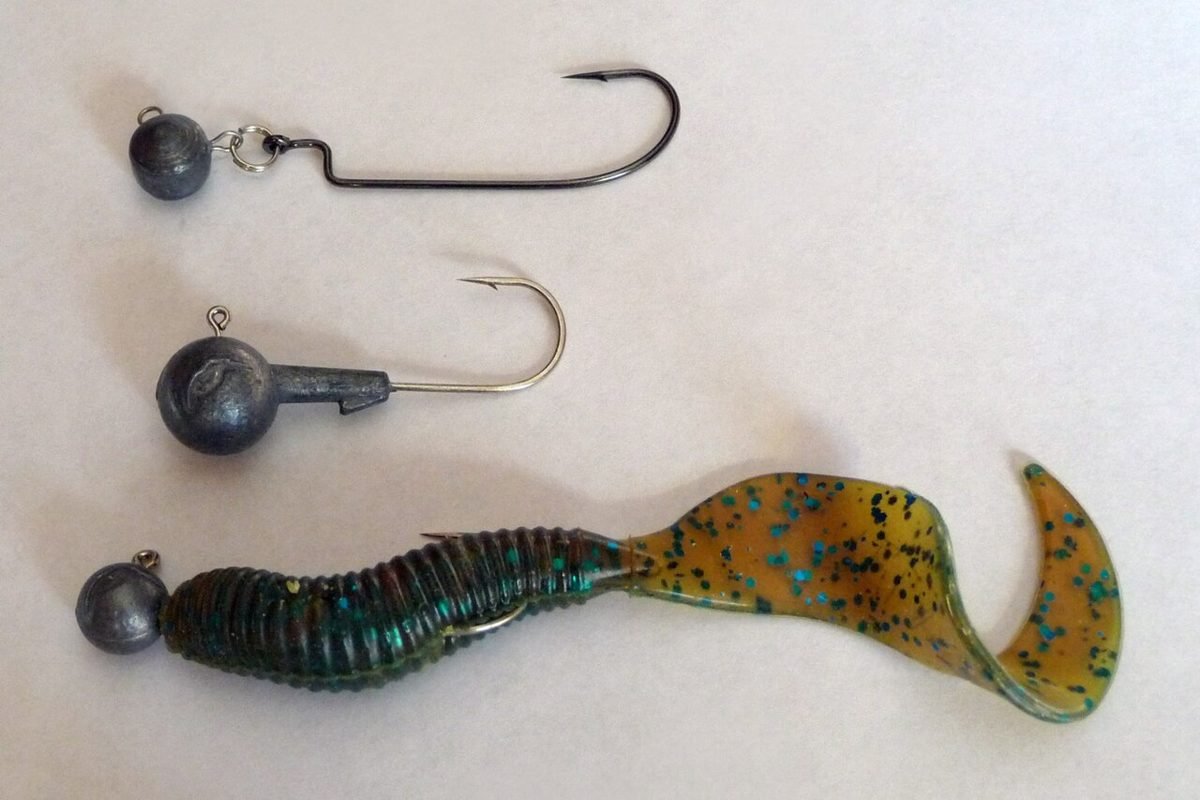 Two round jig heads and a jig head rigged with a curly-tail soft plastic