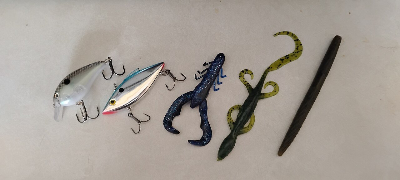 Two lipless crankbaits next to soft plastic bass lures