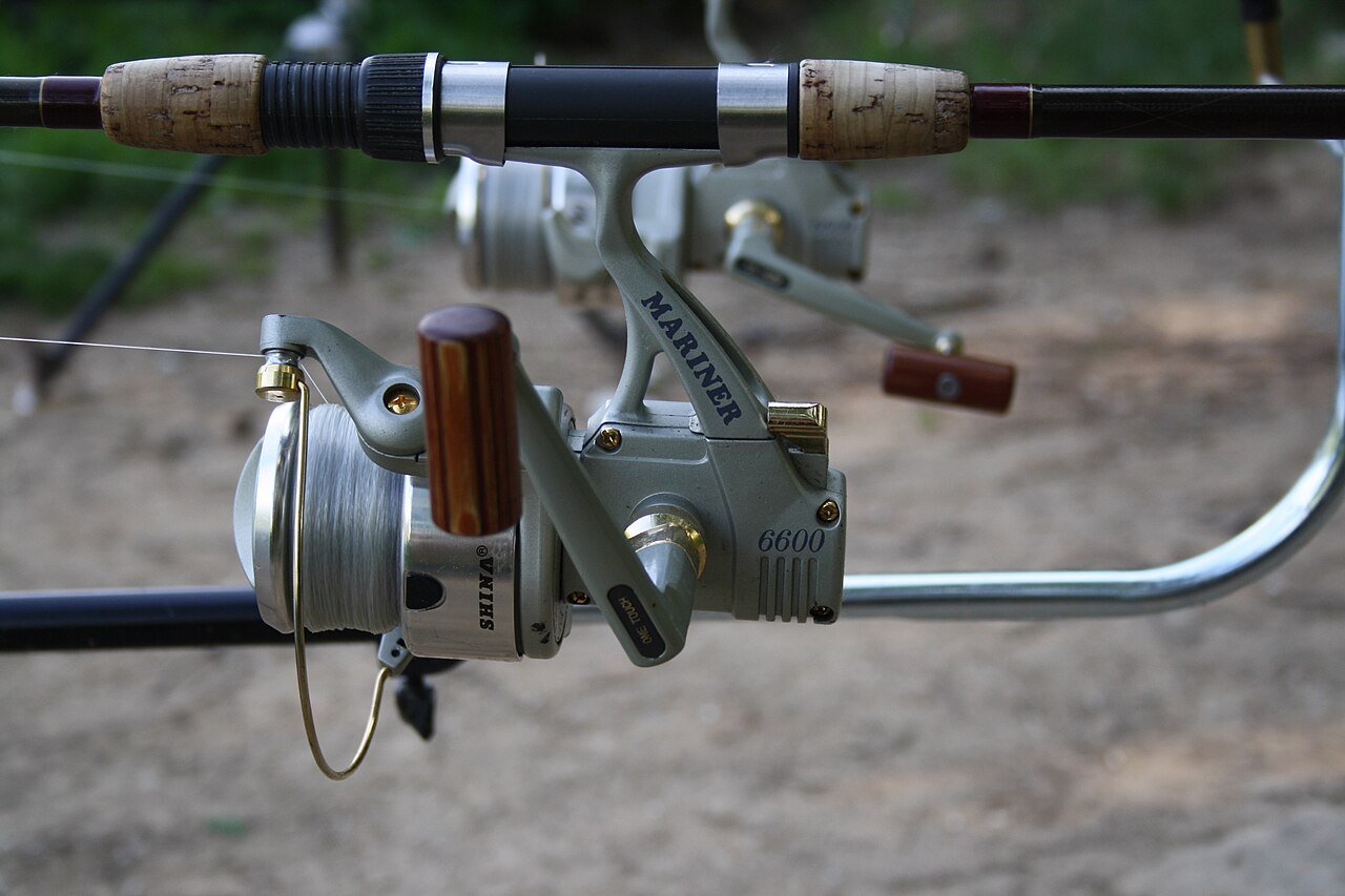 Spinning reel on a rod resting in a metal rod holder